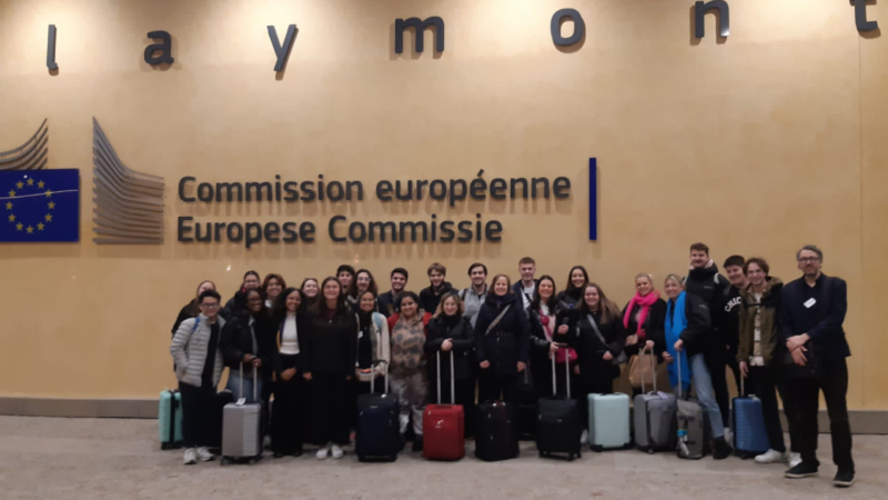 Class poses in front of the European Commission sign in Brussels. 